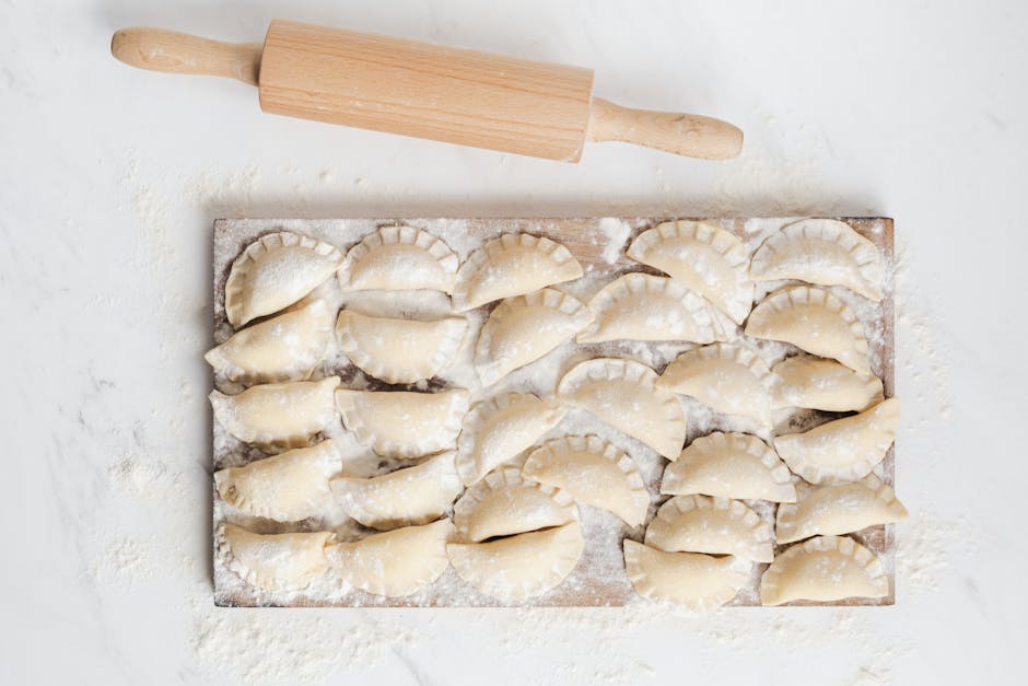 assorted pierogi arranged on wooden board with garnish