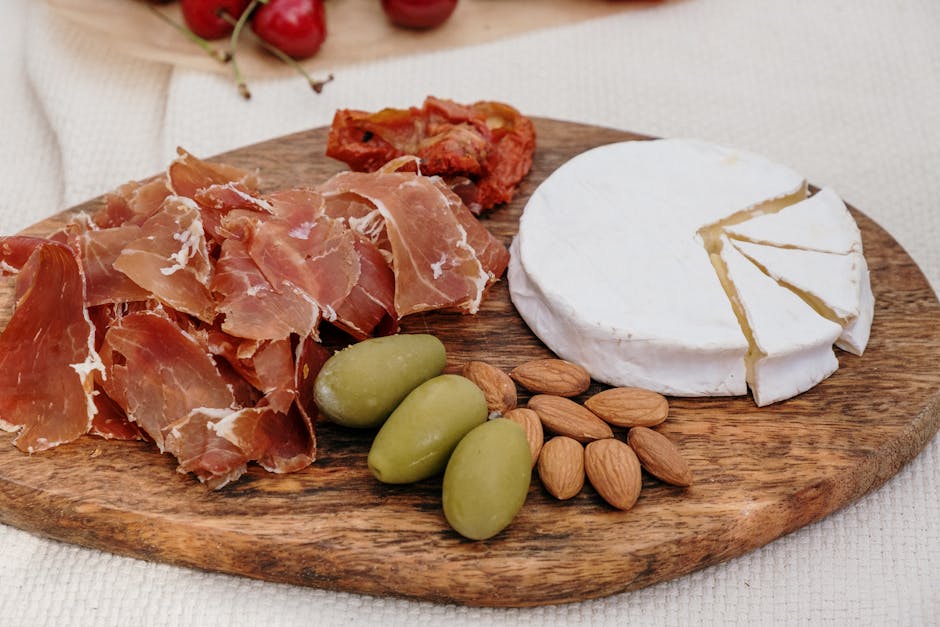 assorted Spanish olives and almonds on wooden board