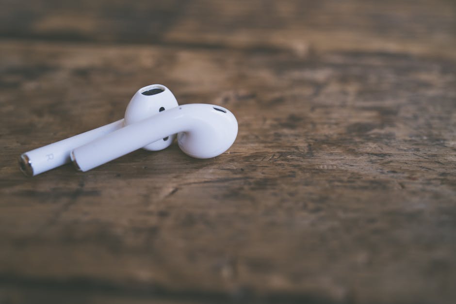 close up of colorful wireless earbuds on wooden table
