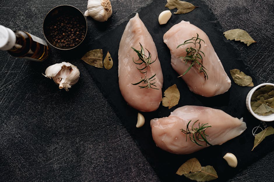 fresh chicken breast and vegetables on kitchen counter