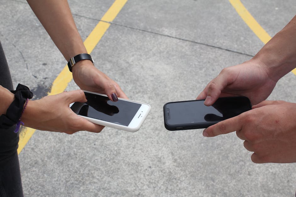 person comparing mobile phones in electronics shop