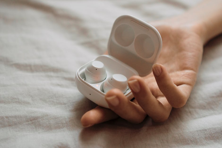 person listening to music with modern white wireless earbuds
