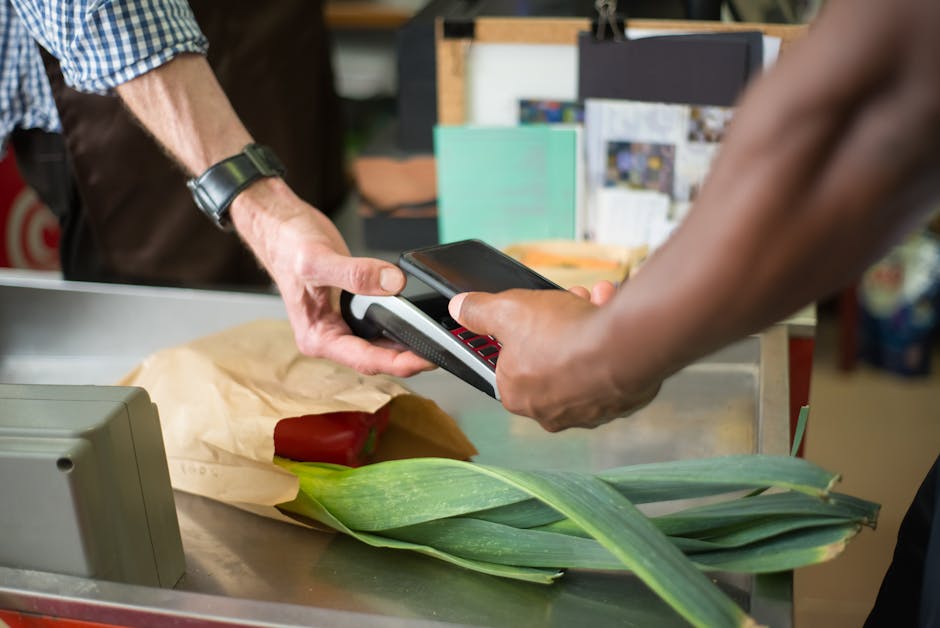 person paying with smartphone at modern store checkout