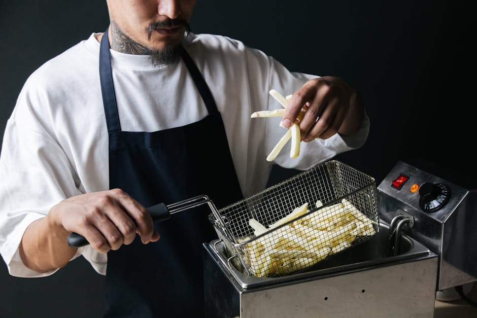 person reaching into open air fryer drawer to check food