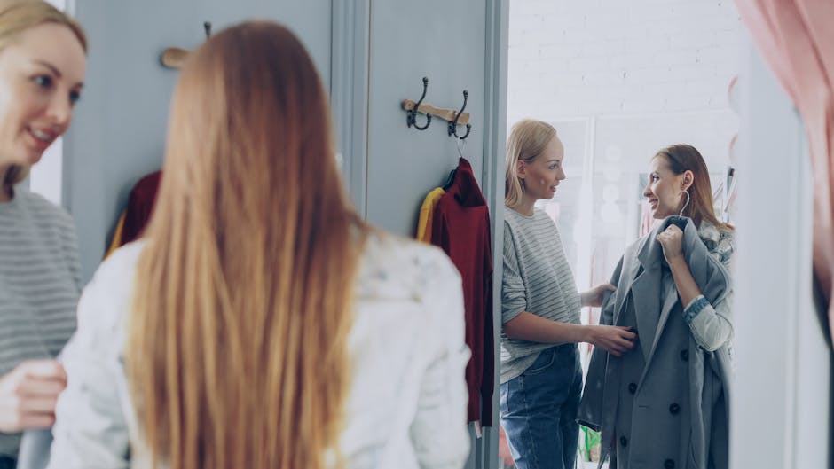 person styling oversized jacket with jeans in boutique fitting room