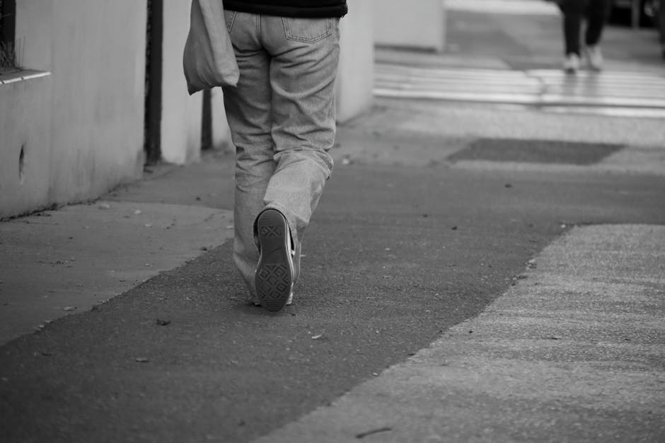person walking city street in white sneakers