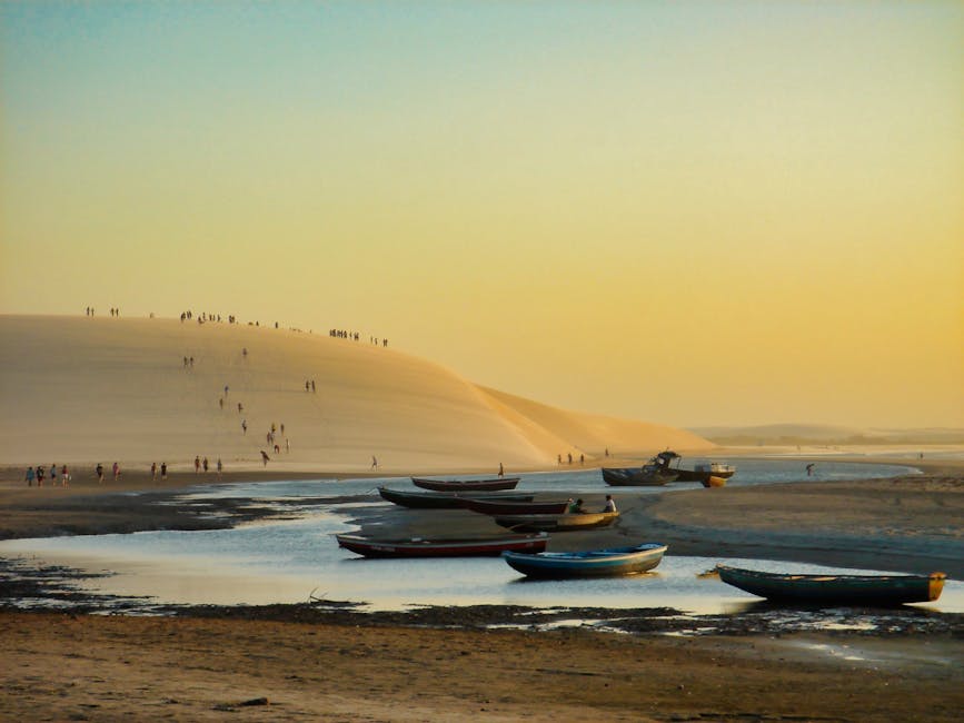 Sunset over golden sand dunes with silhouette of traveler, Jericoacoara Brazil