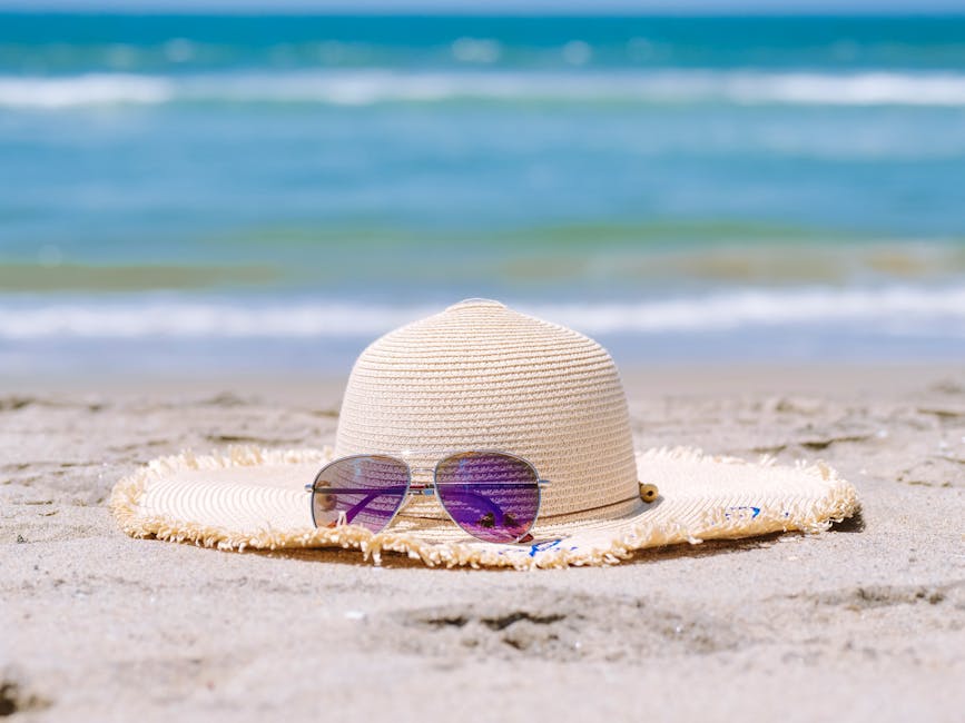 trendy beach accessories minimal jewelry sunglasses and straw hat near ocean