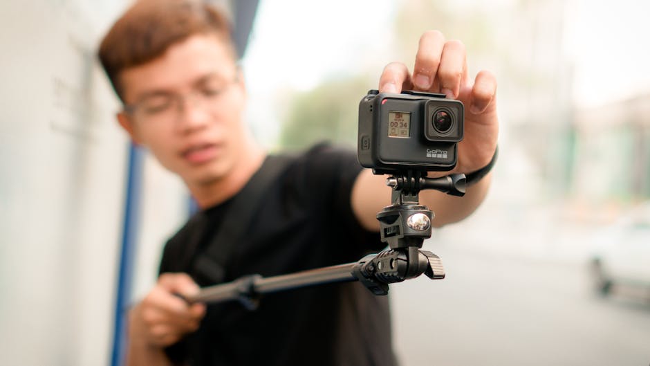 vlogger holding action camera while hiking in alps
