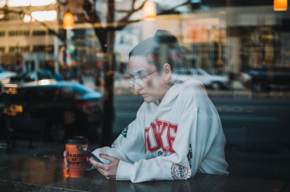 woman comparing products on a mobile phone at a coffee shop