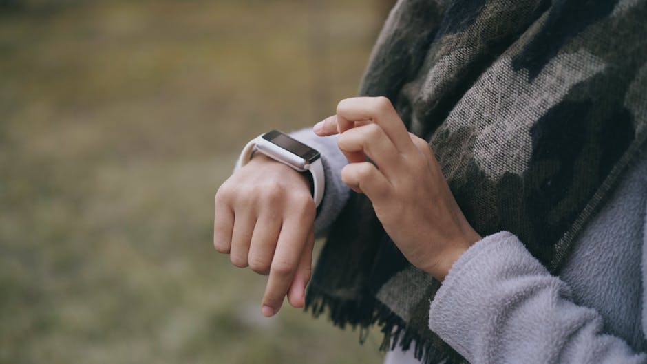 woman wearing smartwatch checking notifications outdoors