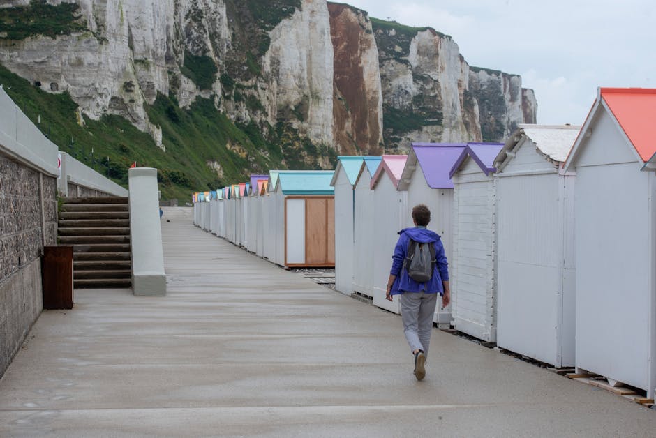 woman with backpack walking past colorful French storefronts