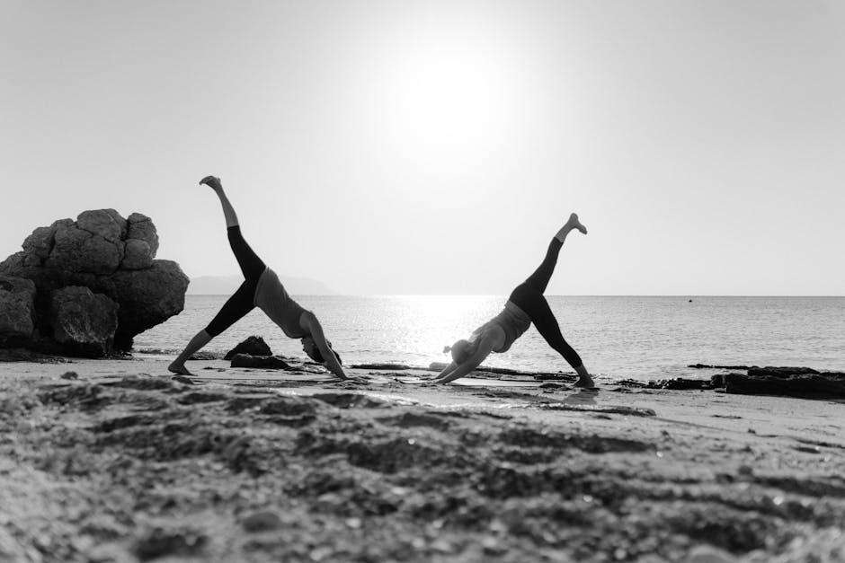 women doing yoga at sunrise on beach