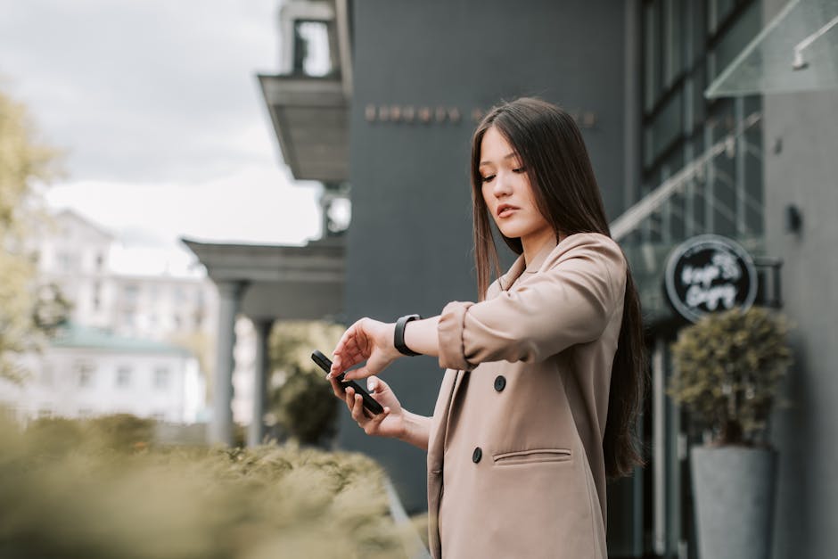 Young woman checking smartwatch notifications in city